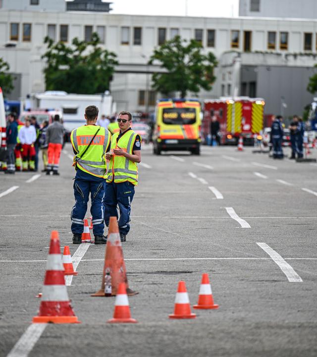 Nach dem Fund einer Weltkriegsbombe müssen rund 27.000 bis 30.000 Menschen ihre Wohnungen und Häuser im Sperrradius um die Fundstelle verlassen. Einsatzkräfte und zahlreiche Einsatzfahrzeuge stehen vor einem Gebäude.