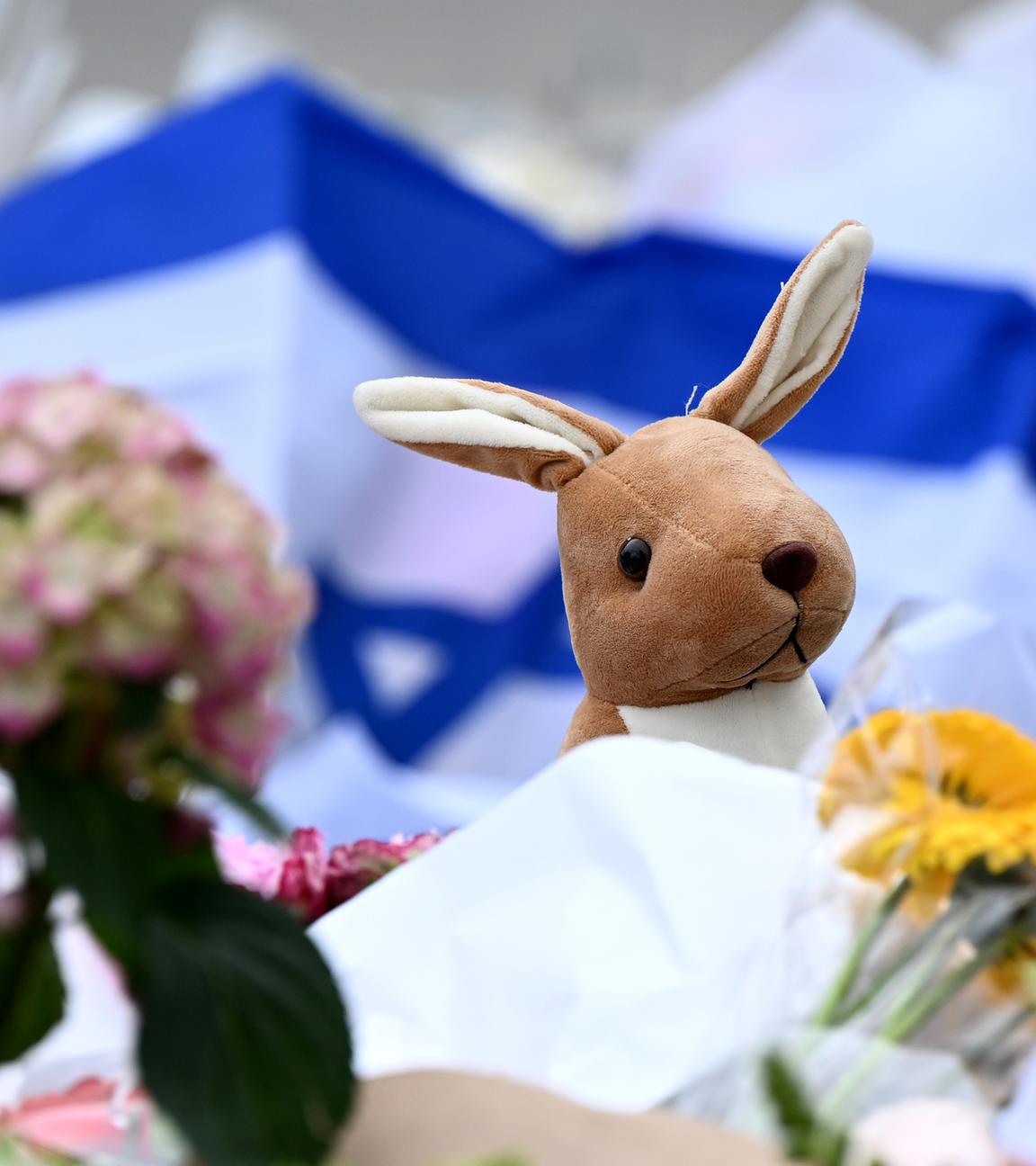 Ein Kuscheltier-Känguru ist neben Blumen und jüdischen Flaggen am 15.12.2025 am Bondi Beach, Australien, niedergelegt worden.
