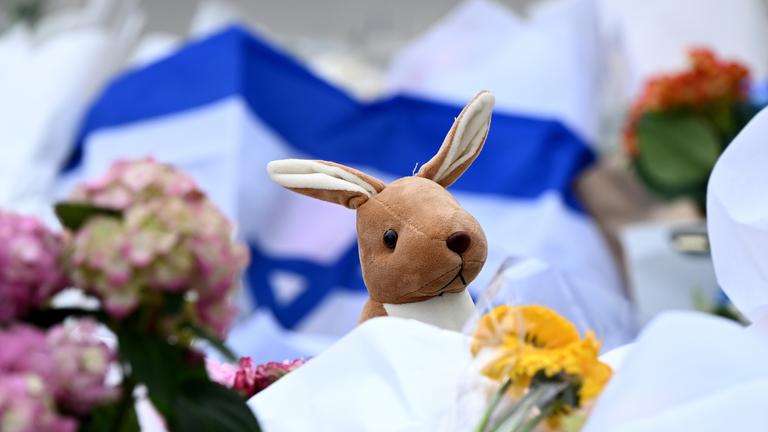 Ein Kuscheltier-Känguru ist neben Blumen und jüdischen Flaggen am 15.12.2025 am Bondi Beach, Australien, niedergelegt worden.