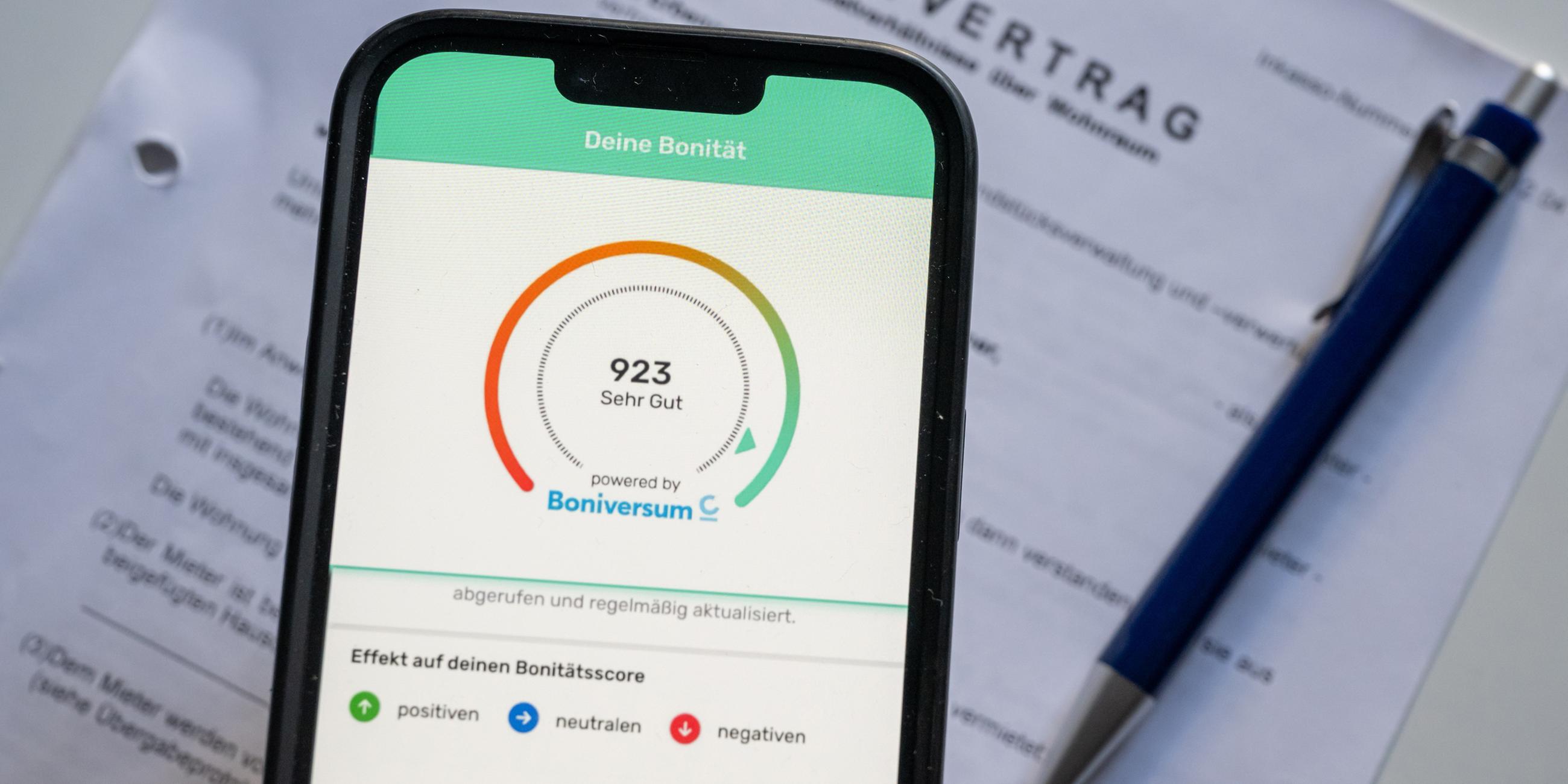 Typical: Ein Screenshot der App Bonify ist auf dem Bildschirm eines Mobiltelefon vor einem Mietvertrag zu sehen.