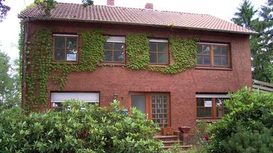 Ein Zweifamilienhaus mit einem kleinen Vorgarten.