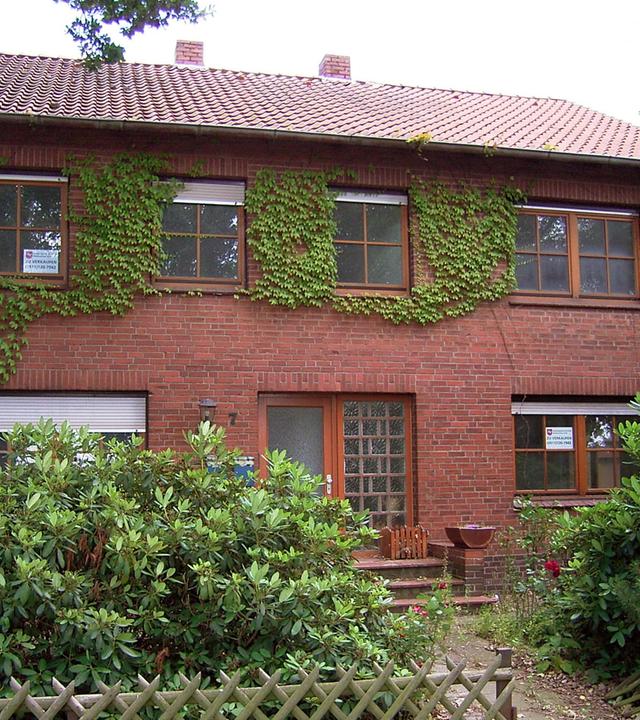 Ein Zweifamilienhaus mit einem kleinen Vorgarten.