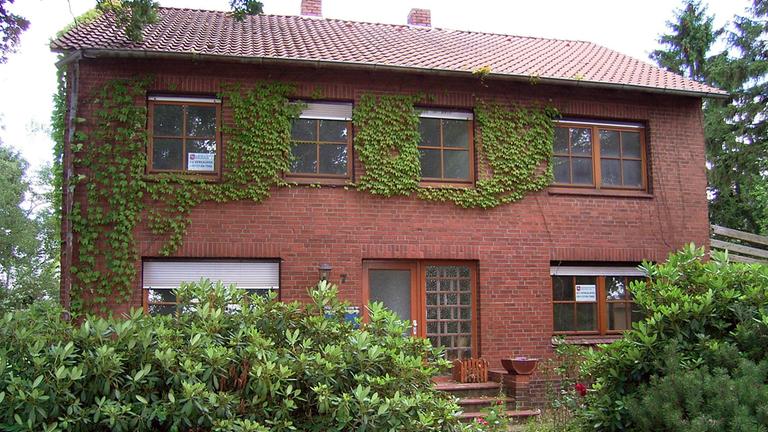 Ein Zweifamilienhaus mit einem kleinen Vorgarten.