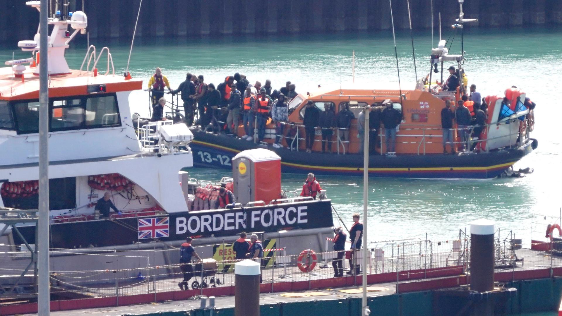 Eine Gruppe von Menschen, bei denen es sich vermutlich um Migranten handelt, wird nach einem Zwischenfall mit einem kleinen Boot im Ärmelkanal an Bord des RNLI-Rettungsboots Dungeness nach Dover (Kent) gebracht.