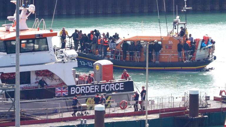 Eine Gruppe von Menschen, bei denen es sich vermutlich um Migranten handelt, wird nach einem Zwischenfall mit einem kleinen Boot im Ärmelkanal an Bord des RNLI-Rettungsboots Dungeness nach Dover (Kent) gebracht.