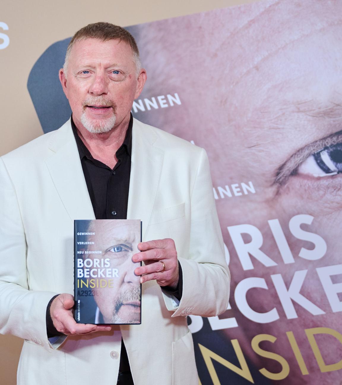 Boris Becker hält sein neues Buch in die Kamera.
