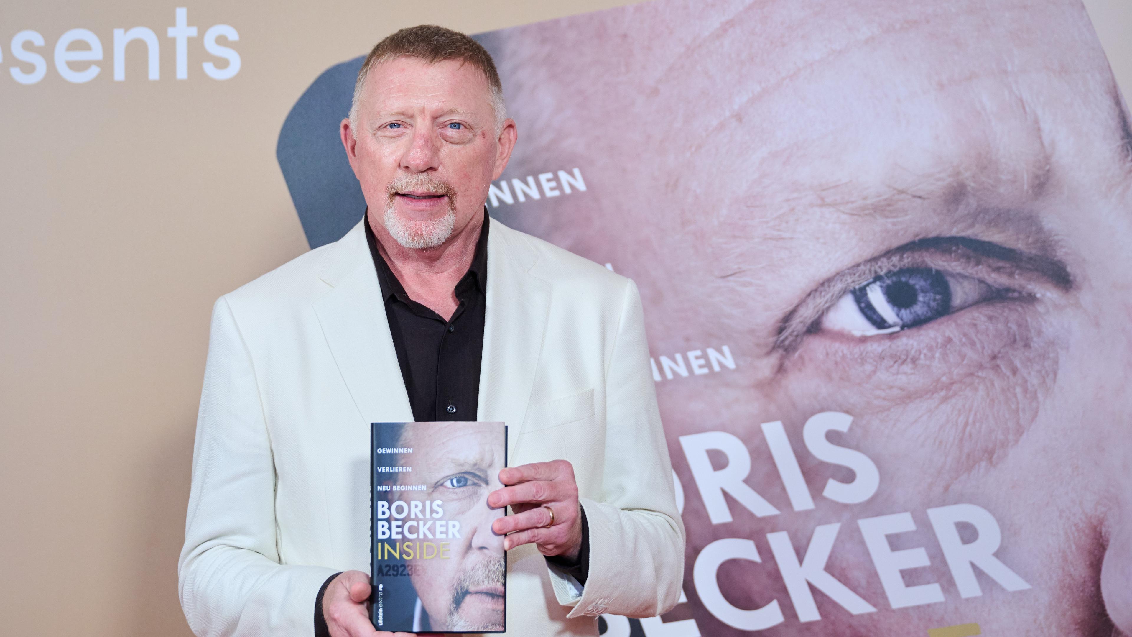 Boris Becker hält sein neues Buch in die Kamera.