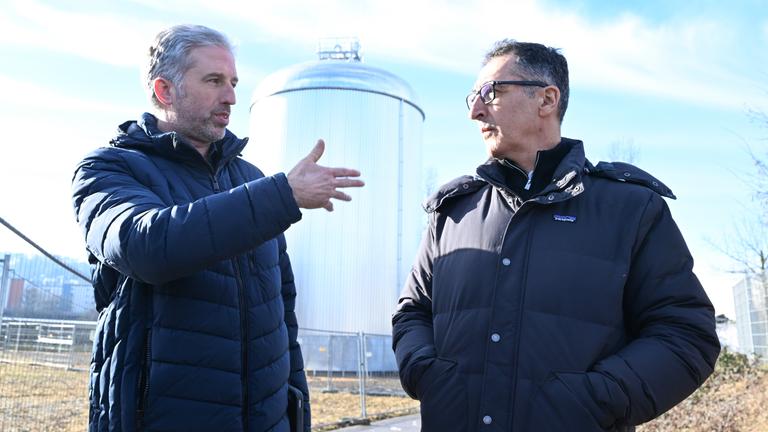 Boris Palmer und Cem Özdemir vor einem Solarthermie-Park, Palmer redet und gestikuliert.