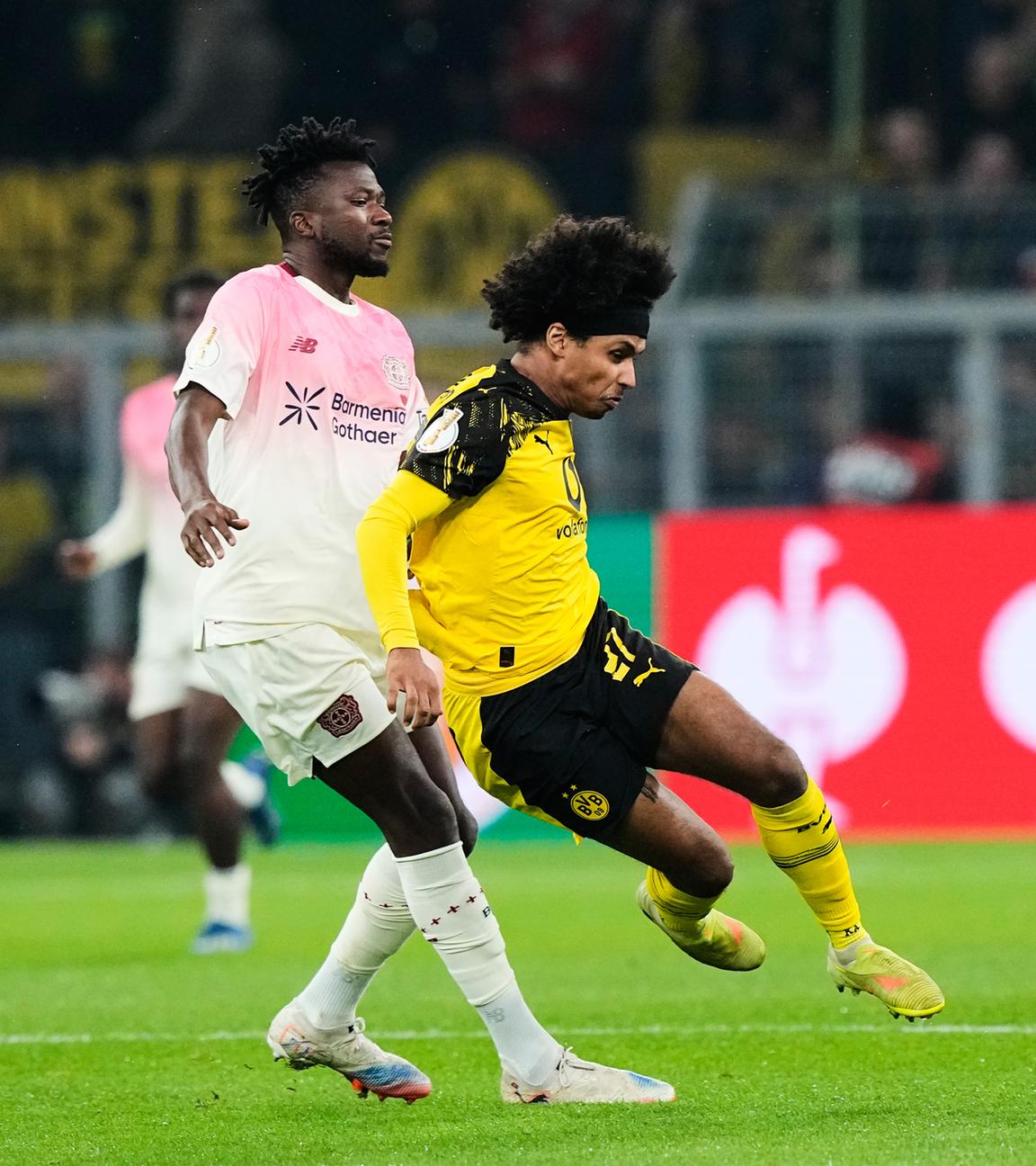 Edmond Tapsoba (Leverkusen) und Karim Adeyemi (Dortmund) kämpfen. 
