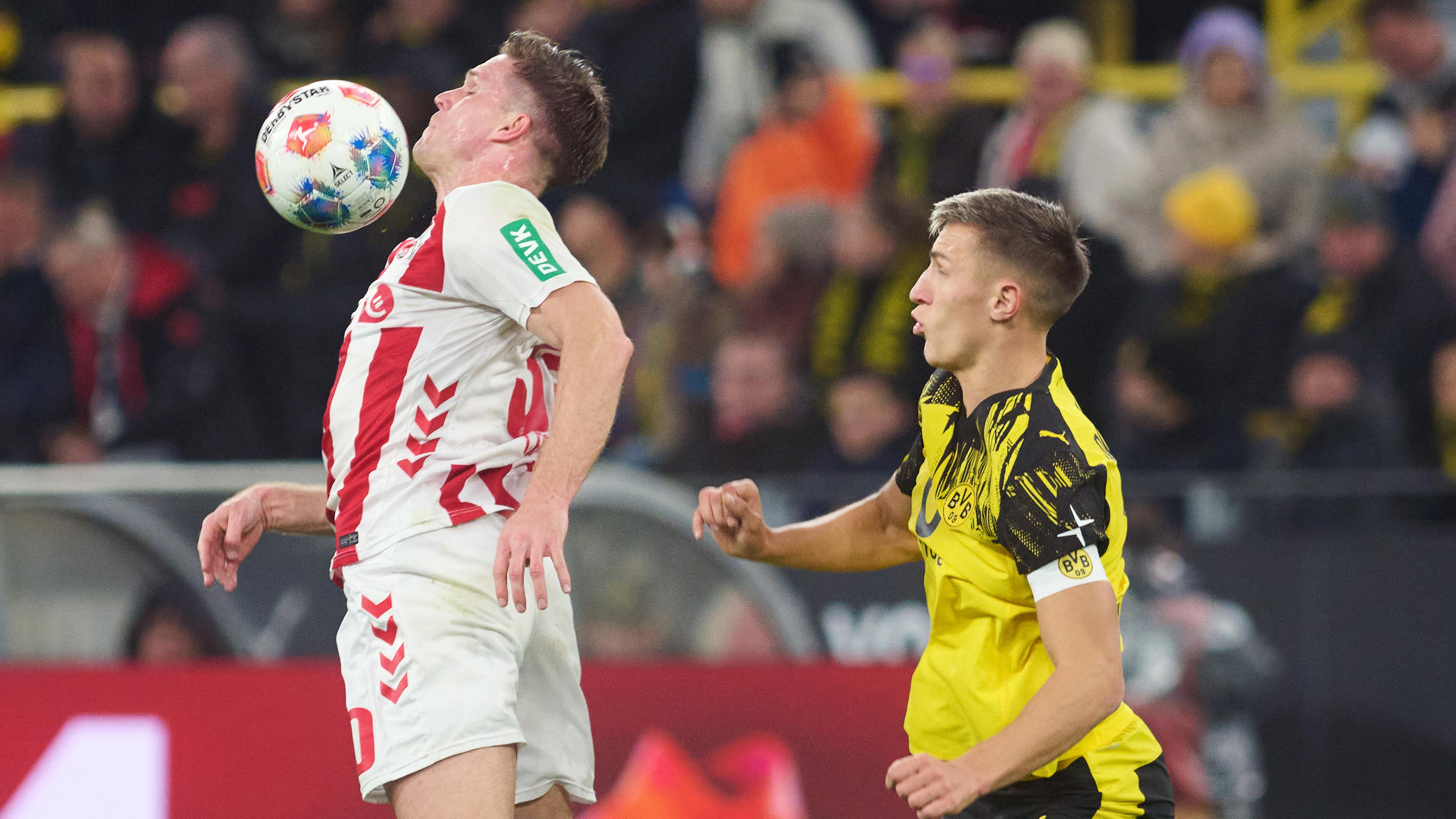 Borussia Dortmund spielt gegen den 1. FC Köln. Bülter (Köln) und Schlotterbeck (BVB) in Aktion. 