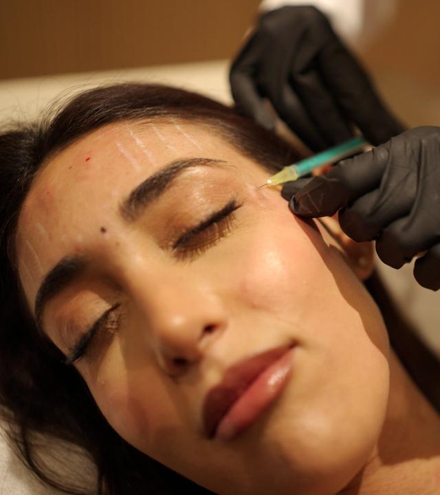 Eine junge Frau während einer Botox-Behandelung.