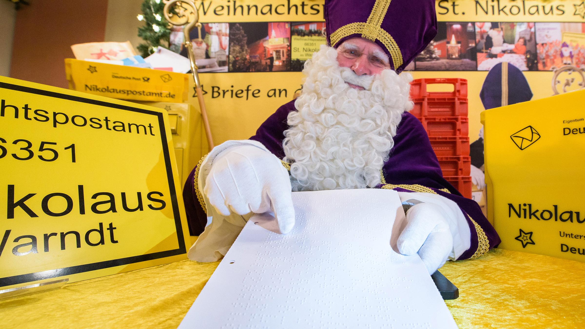 Archiv: Ein Nikolaus hält im Nikolauspostamt einen Brief in der Blindenschrift "Braille" in der Hand