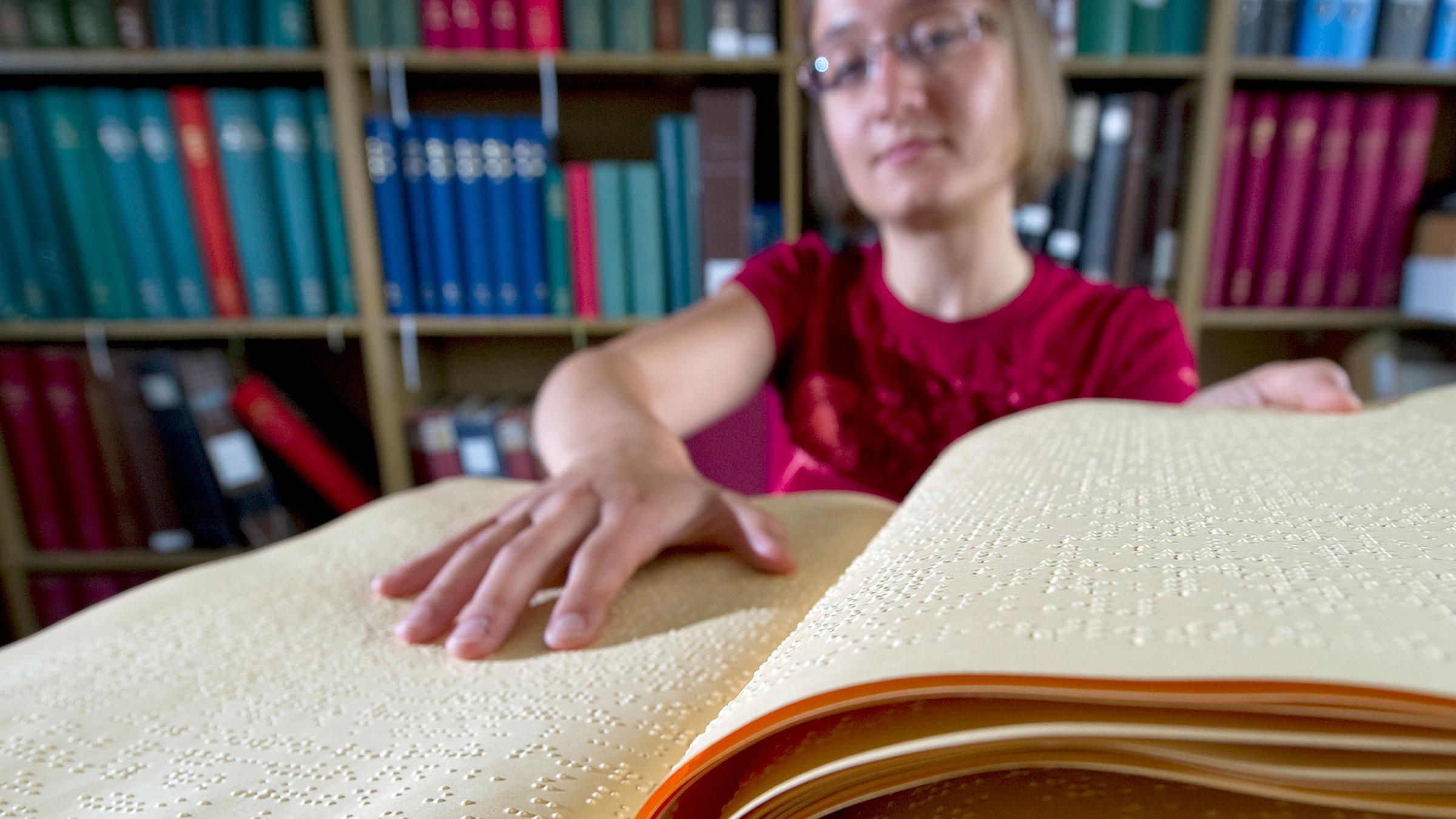 Archiv: Eine Mitarbeiterin der Deutschen Zentralbücherei für Blinde (DZB) in Leipzig, Clara Schneider, schlägt am 05.07.2011 ein Fachbuch in Brailleschrift auf. 