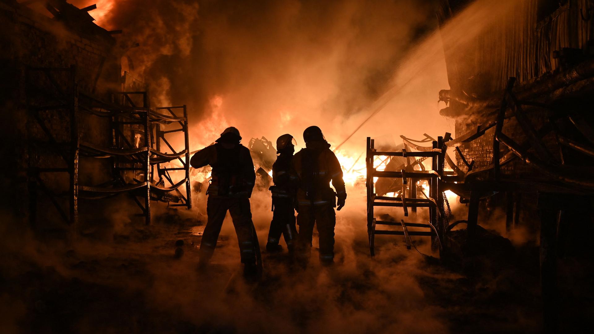 Ukrainische Feuerwehrleute löschen ein Feuer am Ort eines Drohnenangriffs auf Industrieanlagen in Charkiw am 04.05.2024