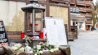 Vor dem Eingang der nun geschlossenen Bar "Le Constellation", in der am Silvesterabend ein Brand ausgebrochen ist, stehen Kerzen zum Gedenken an die Opfer des Brandes.