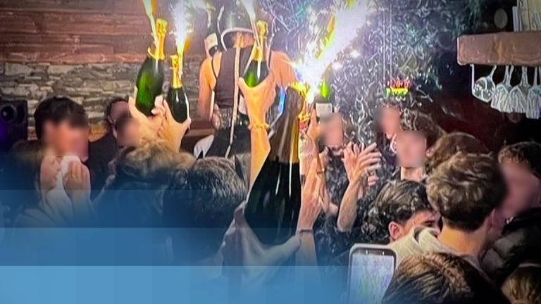 Gäste der Bar "Le Constellation" in Crans-Montana feiern mit großen Wunderkerzen und Sektflaschen.