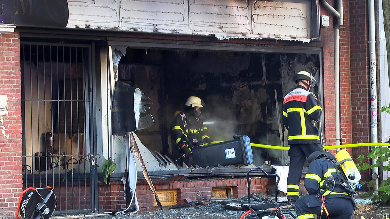 Einsatzkräfte der Feuerwehr arbeiten in einem ausgebrannten Kosmetikstudio im Hamburger Stadtteil Hohenfelde. 