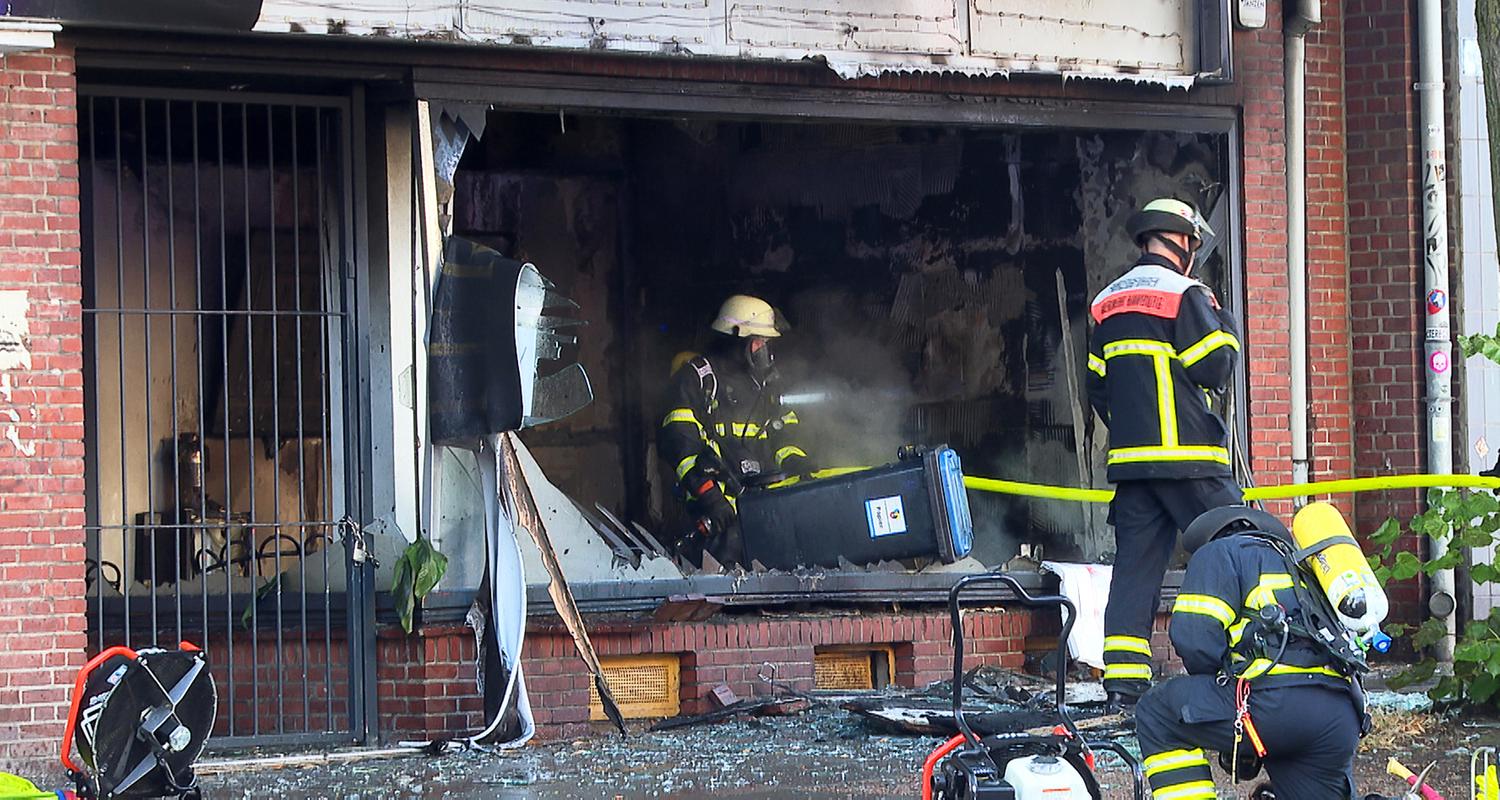 Einsatzkräfte der Feuerwehr arbeiten in einem ausgebrannten Kosmetikstudio im Hamburger Stadtteil Hohenfelde. 