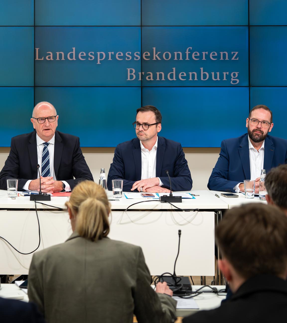Kurt Fischer (l-r, SPD), Dietmar Woidke (SPD), Ministerpräsident von Brandenburg, Jan Redmann, Vorsitzender der Brandenburger CDU, und Gordon Hoffmann (CDU) sitzen während einer Pressekonferenz zur Vorstellung des Brandenburger Koalitionsvertrages von SPD und CDU nebeneinander. 