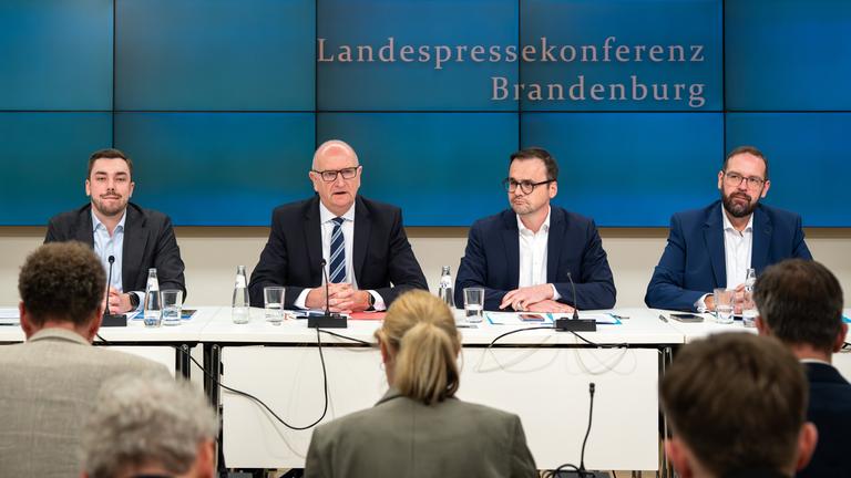 Kurt Fischer (l-r, SPD), Dietmar Woidke (SPD), Ministerpräsident von Brandenburg, Jan Redmann, Vorsitzender der Brandenburger CDU, und Gordon Hoffmann (CDU) sitzen während einer Pressekonferenz zur Vorstellung des Brandenburger Koalitionsvertrages von SPD und CDU nebeneinander. 