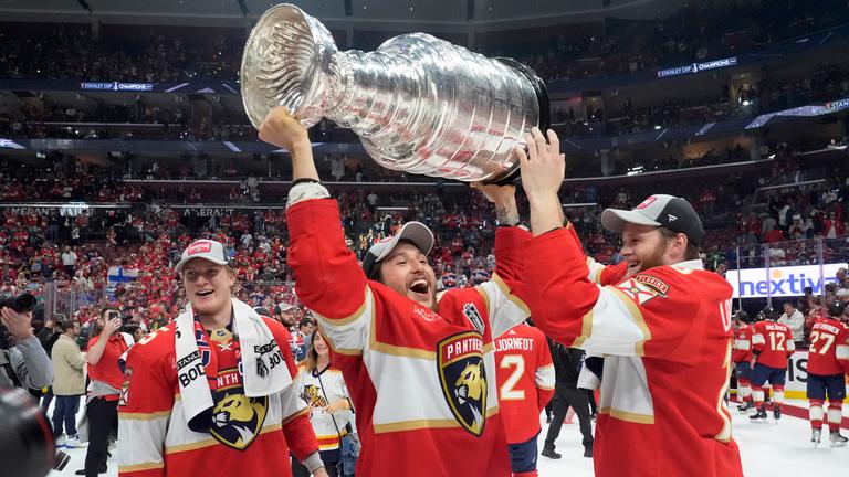 Brandon Montour, Verteidiger der Florida Panthers, Mitte, hebt die Stanley-Cup-Trophäe nach Spiel 7 des NHL-Hockey-Stanley-Cup-Finales gegen die Edmonton