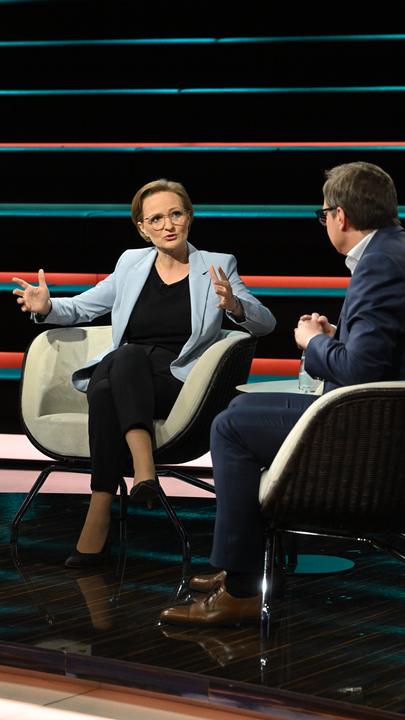 Franziska Brantner spricht gestikulierend in Richtung Martin Huber, der nur von hinten zu sehen ist. 