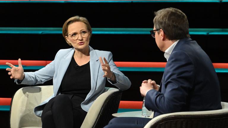 Franziska Brantner spricht gestikulierend in Richtung Martin Huber, der nur von hinten zu sehen ist. 