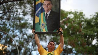 Brasiliens Präsidentschaftskandidat Flávio Bolsonaro hält das Bild seines Vaters, dem ehemaligen und verurteilten Präsidenten Jair Bolsonaro, hoch.