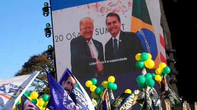 Eine Menschenmenge steht vor einer Leinwand,a uf der US-Präsident Donald Trump und Brasiliens Ex-Präsident Jair Bolsonaro zu sehen sind.