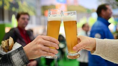 Zwei Personen stoßen mit Bier an