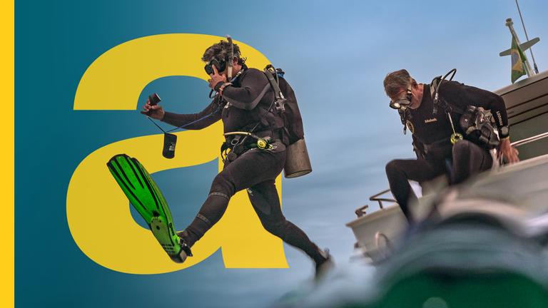 Ein Taucher springt vom Boot ins Meer