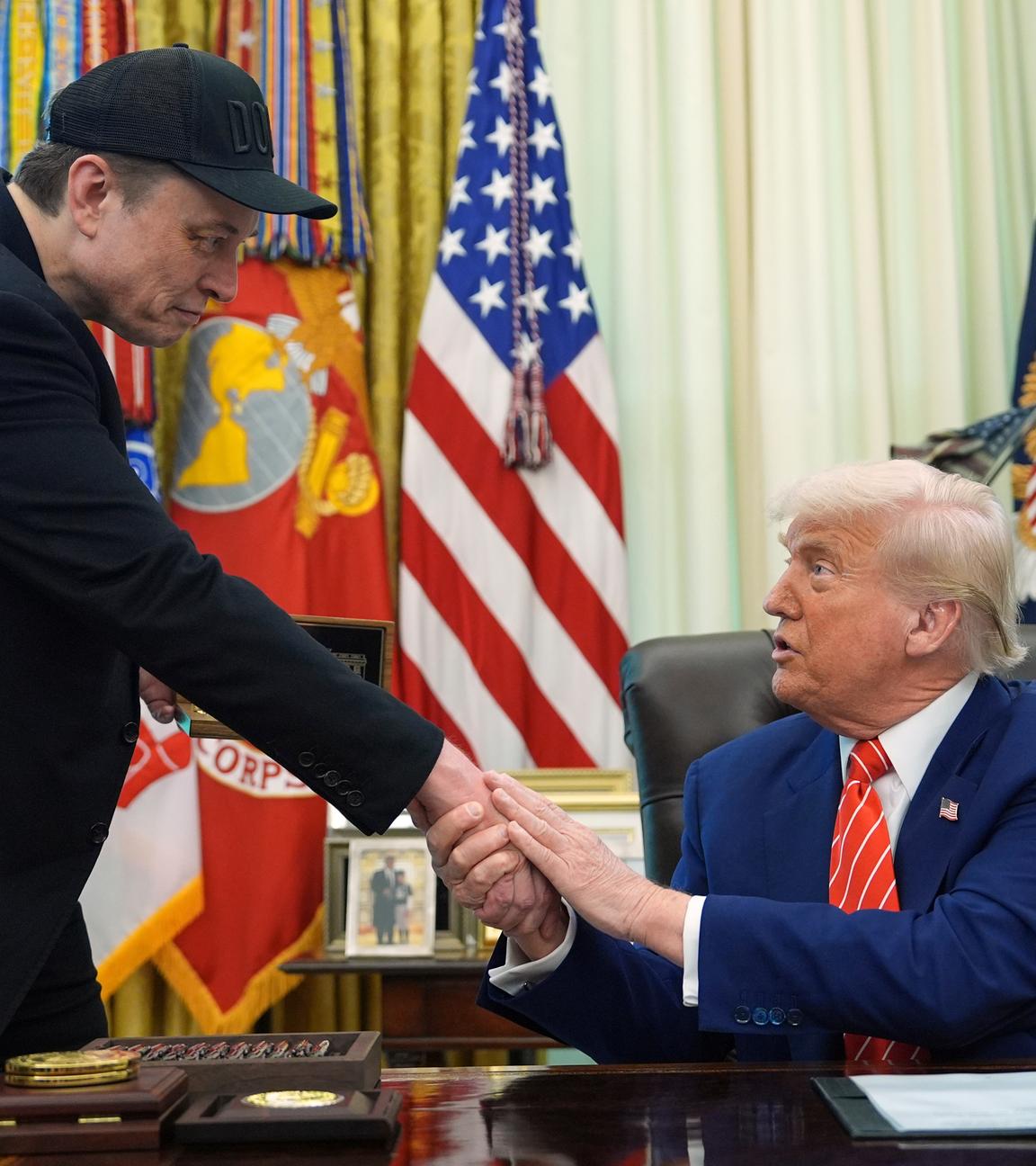 US-Präsident Donald Trump (r) schüttelt die Hand von seinem Berater Elon Musk während einer Pressekonferenz im Oval Office des Weißen Hauses