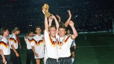 zwei Fußballer (Andreas Brehme sowie Lothar Matthäus) strecken den Weltmeisterpokal in die Höhe 