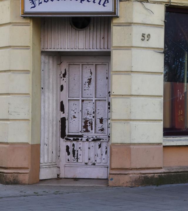 Bremen, Bremerhaven: Ein Mann geht an einem kaputten Fenster einer geschlossenen Kneipe entlang.