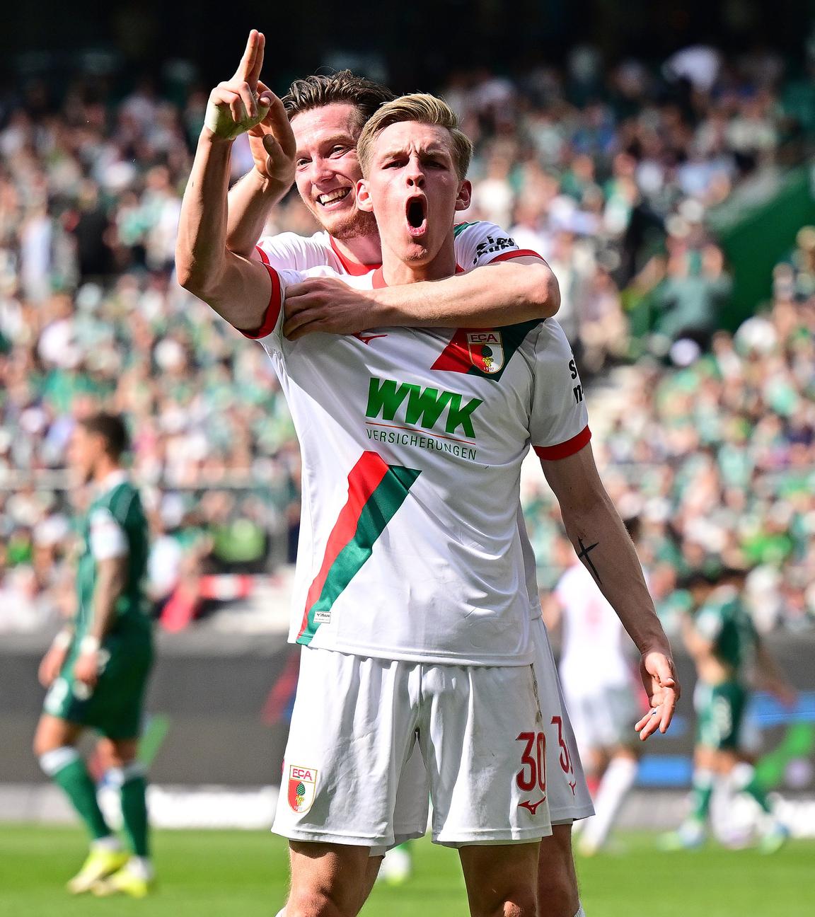 Anton Kade (FC Augsburg, Torschütze) jubelt mit Michael Gregoritsch (l.) im Spiel gegen Werder Bremen.