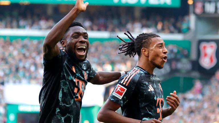 Bayern Münchens Mittelfeldspieler (Nr. 17) Michael Olise (R) feiert mit Bayern Münchens  Verteidiger (Nr. 19) Alphonso Davies nach seinem Treffer zum 0:4.