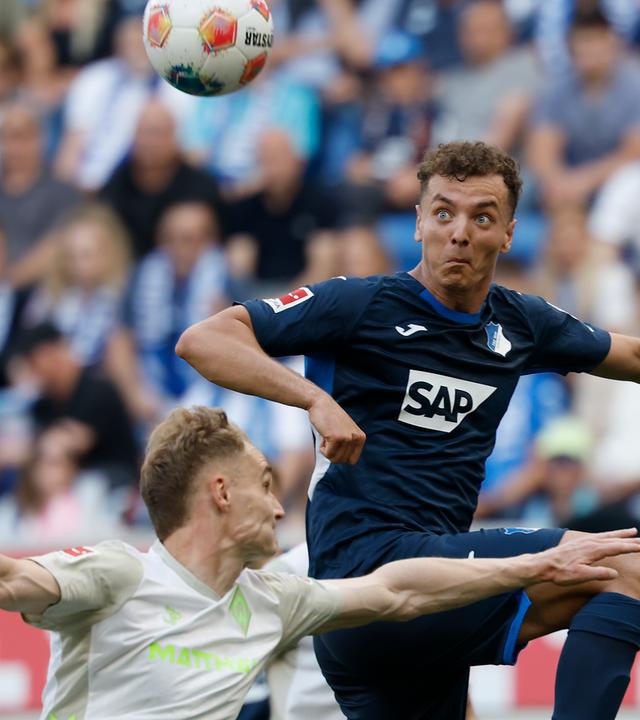 Hoffenheims Mittelstürmer Fisnik Asllani setzt im Zweikampf mit Bremens Innenverteidiger Amos Pieper zum Kopfball an