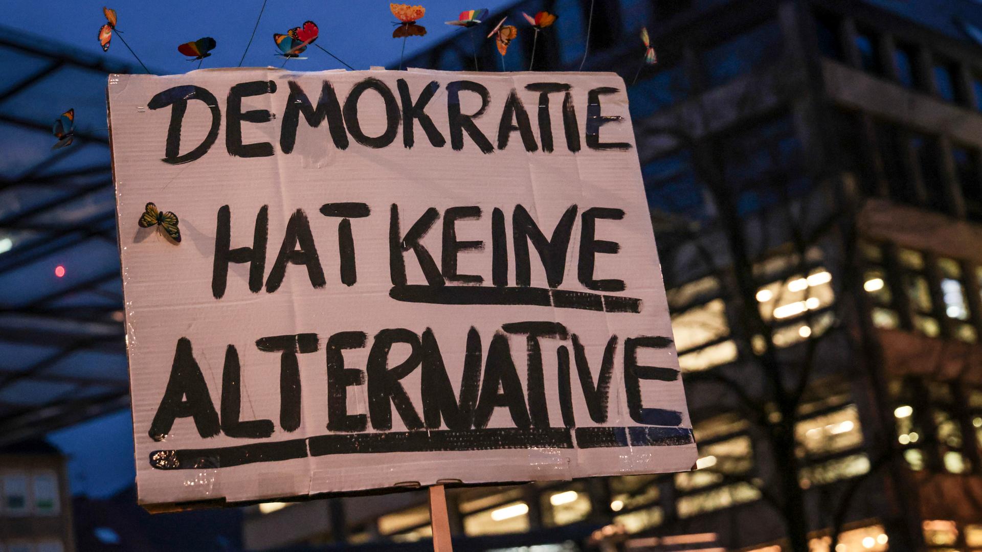Bremen: Ein Teilnehmer einer Kundgebung unter dem Motto "Zusammen stabil, wir bleiben laut!" auf dem Domshof in Bremen hält ein Plakat mit der Aufschrift "Demokratie hat keine Alternative".