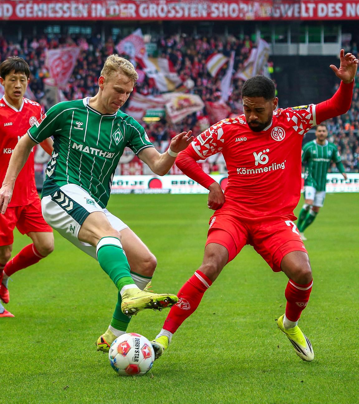 Marco Grüll (SV Werder Bremen) und Phillipp Mwene (1. FSV Mainz 05) kämpfen am 15.03.2026 in Bremen um den Ball. 