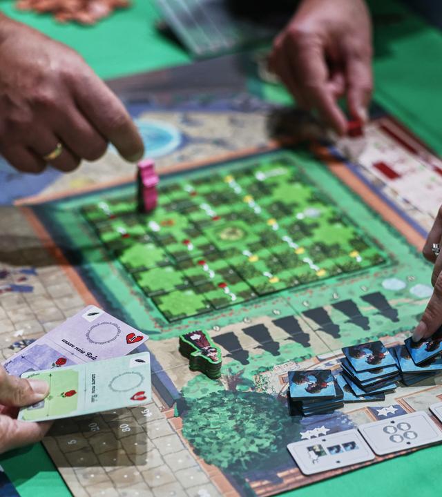  Menschen spielen auf der Publikumsmesse "Spiel Essen" das Brettspiel Roxane. Laut Veranstalter werden zur weltgrößten Publikumsmesse für Brettspiele rund 230.000 Besucherinnen und Besucher aus aller Welt erwartet