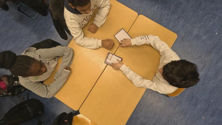 Drei SchülerInnen spielen ein Spiel