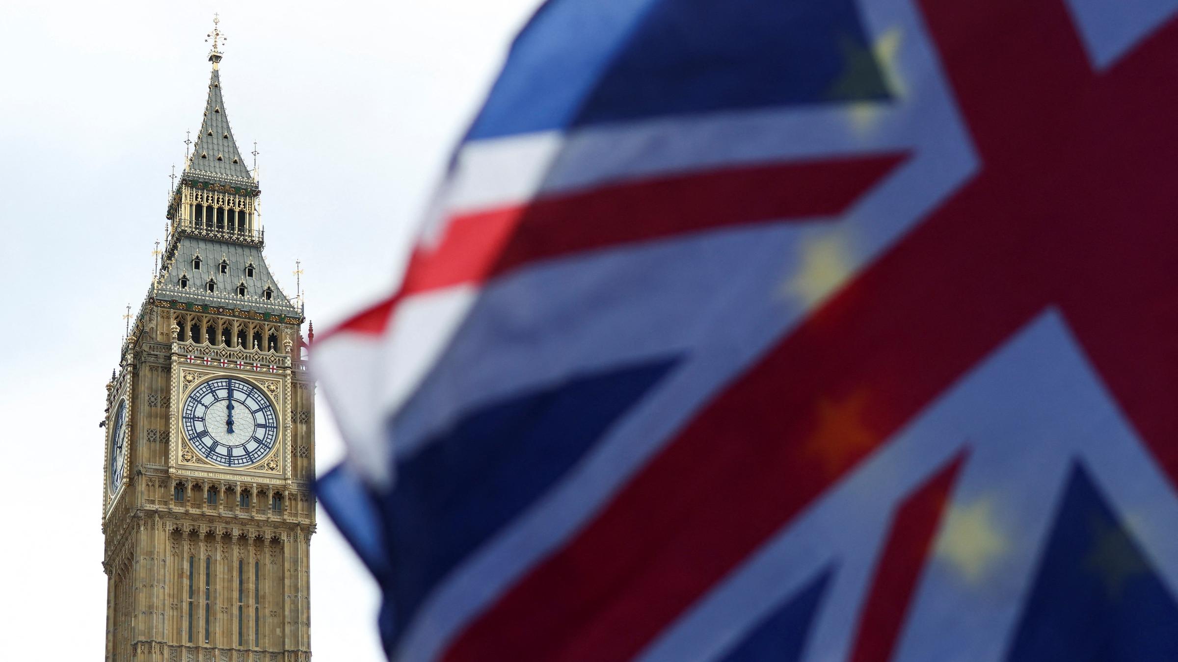 Links den Turm der Big Ben, rechts eine Großbritannienflagge