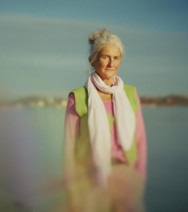 Auf dem Foto ist Britta zu sehen, eine Dame Ende 50, sie steht vor einem See.