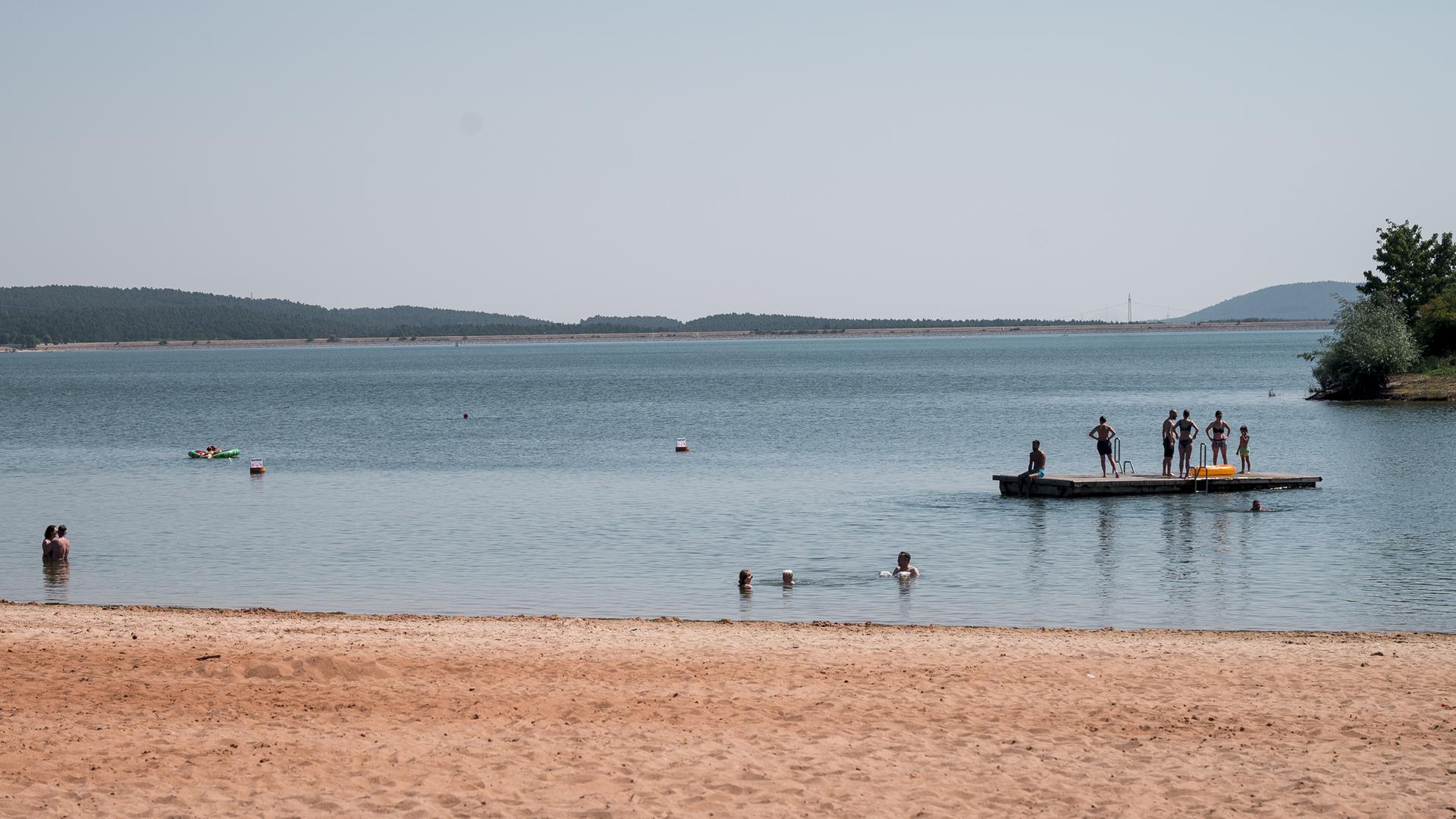  Badegäste sind im Wasser und auf einem schwimmenden Floß