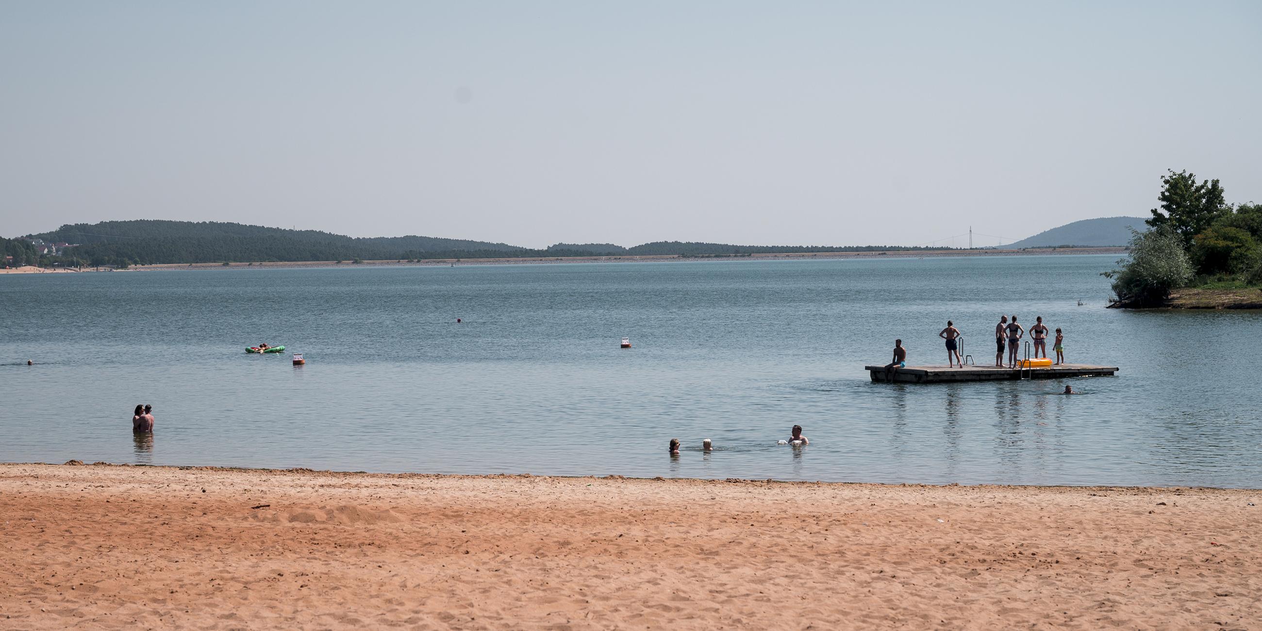  Badegäste sind im Wasser und auf einem schwimmenden Floß