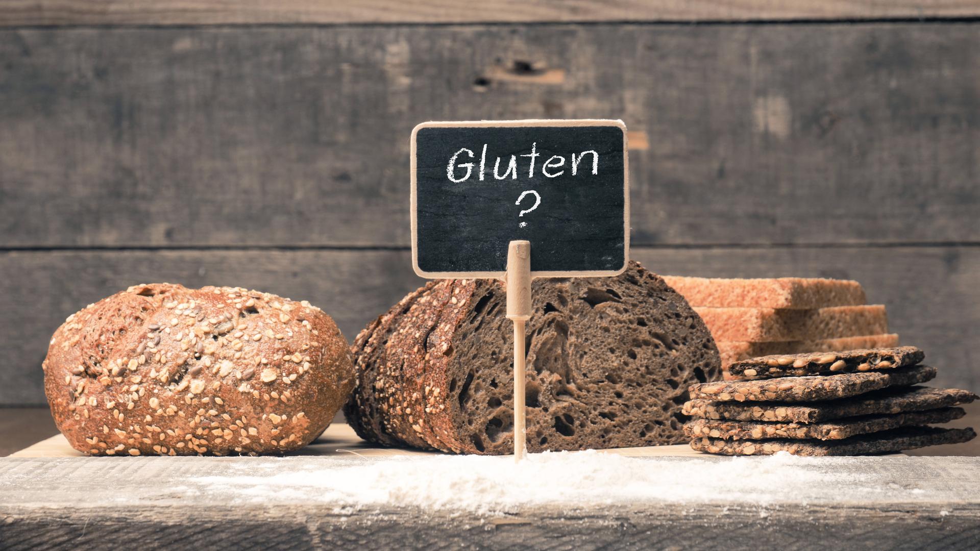 Eine kleine Tafel mit der Aufschrift Gluten ist vor verschiedenen Brotsorten aufgestellt.