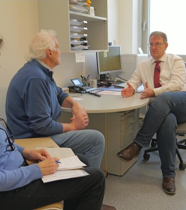 Älterer Mann und Frau bei einem Arzt im Patientenzimmer 