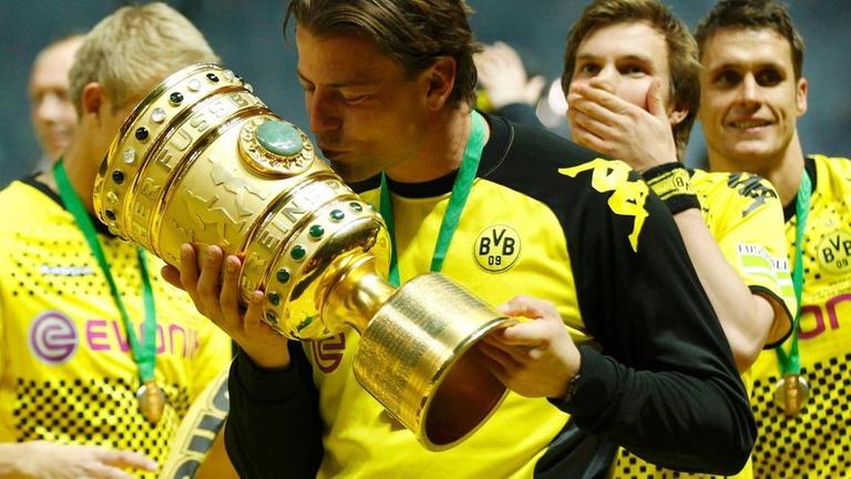 borussia dortmund's roman weidenfeller kisses the trophy after defeating bayern munich to win the german dfb cup (dfb pokal) final soccer match at the olympic stadium in berlin, may 12, 2012.    reuters/ina fassbender (germany  - tags: sport soccer) dfb rules prohibit use in mms services via handheld devices until two hours after a match and any usage on internet or online media simulating video footage during the match;dfb