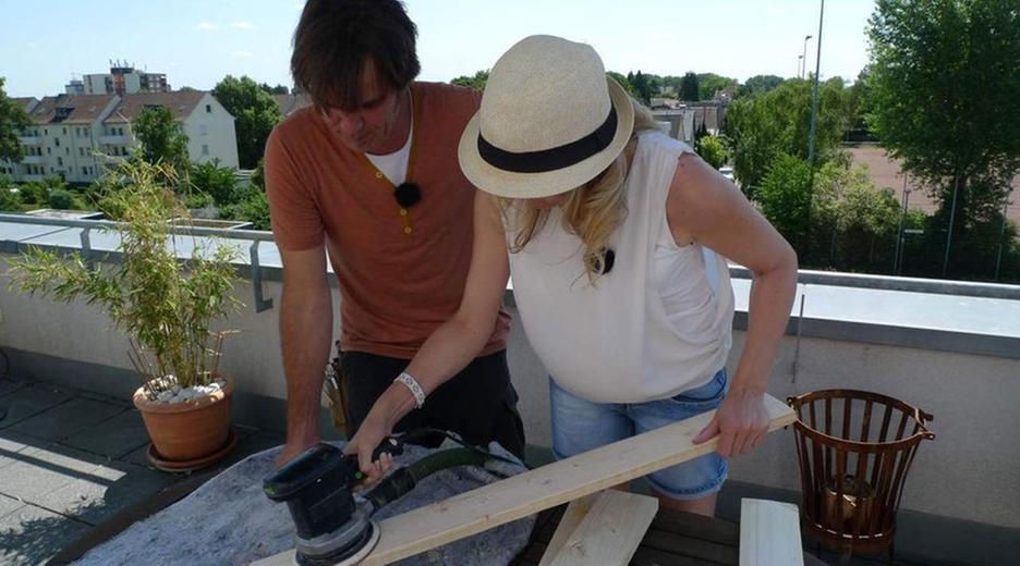 Handwerker und Handwerkerin mit einer Schleifmaschine