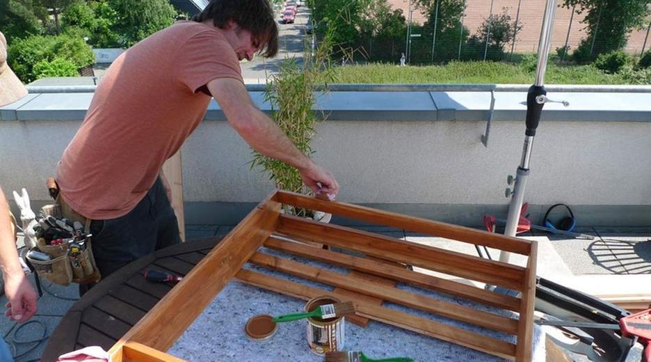 Handwerker mit Lattenkonstruktion auf Balkon